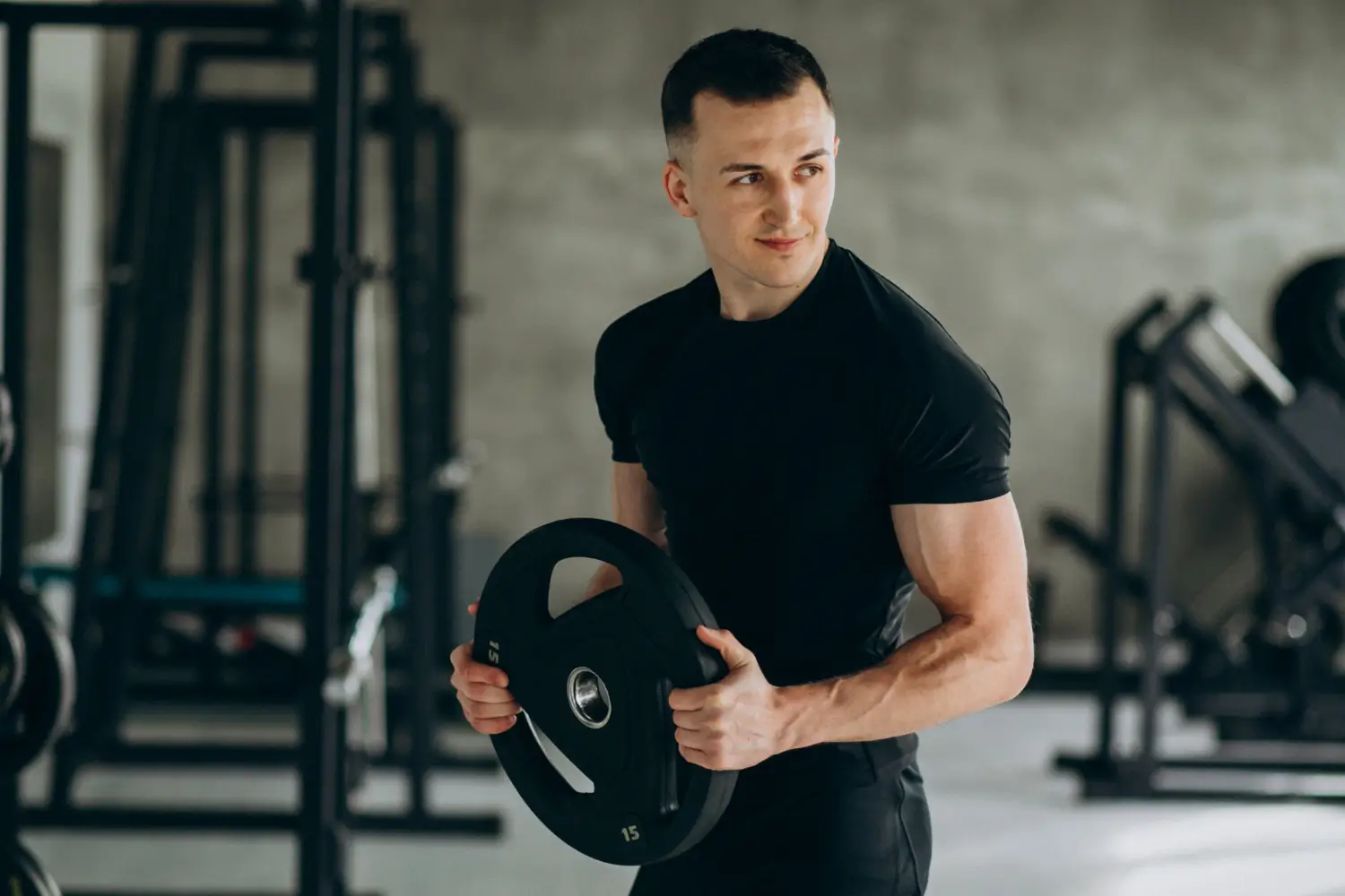 male fitness coach holding dumbbell in gym